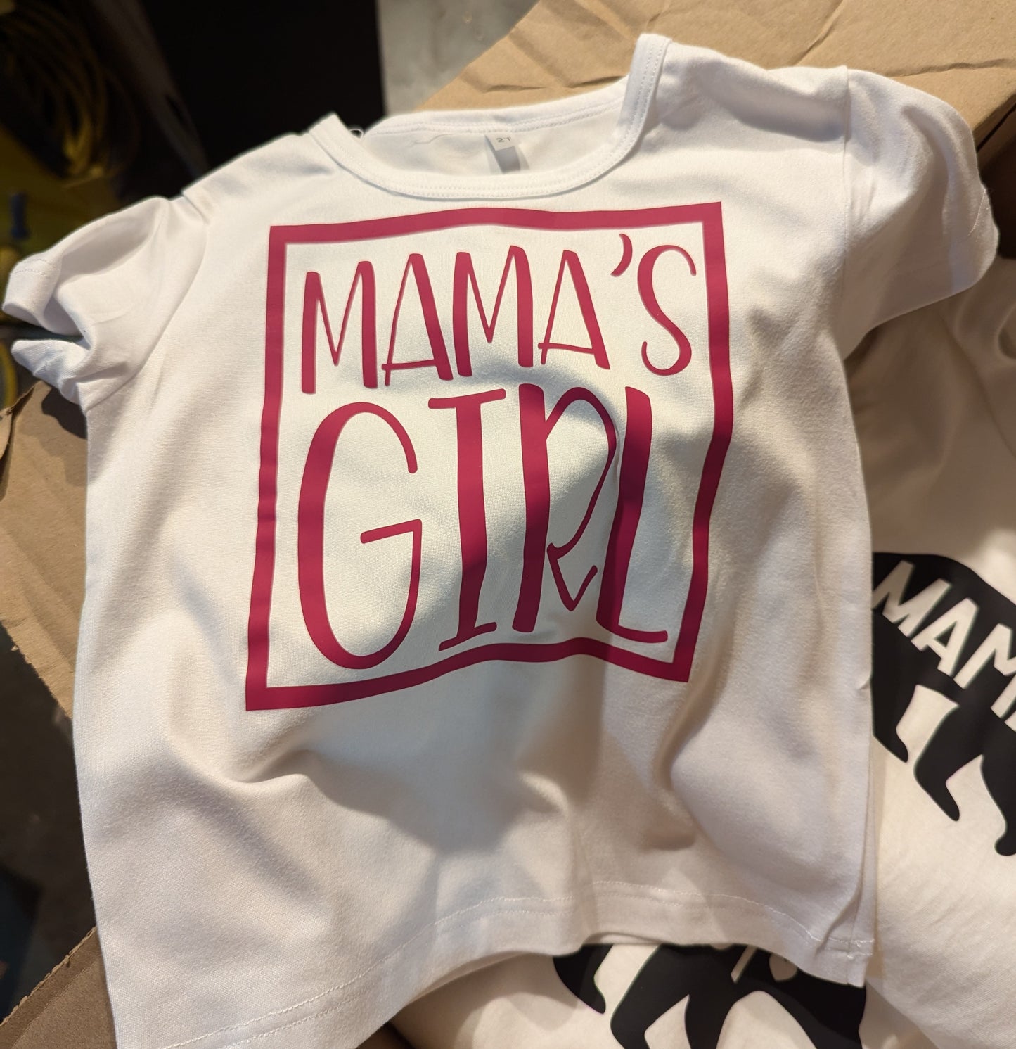 Short sleeve T-shirt with decal that reads Mama's Girl